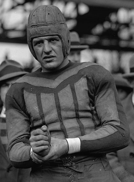 Red Grange holding a football in his Chicago Bears uniform in 1925